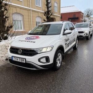 Två av Fawaz trafikskolas vita skolbilar parkerade längs en vintrig gata i centrala Falköping